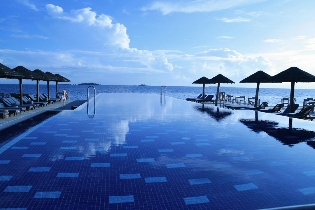 Luxurious infinity pool with ocean view at a tropical resort. Ideal for relaxation.