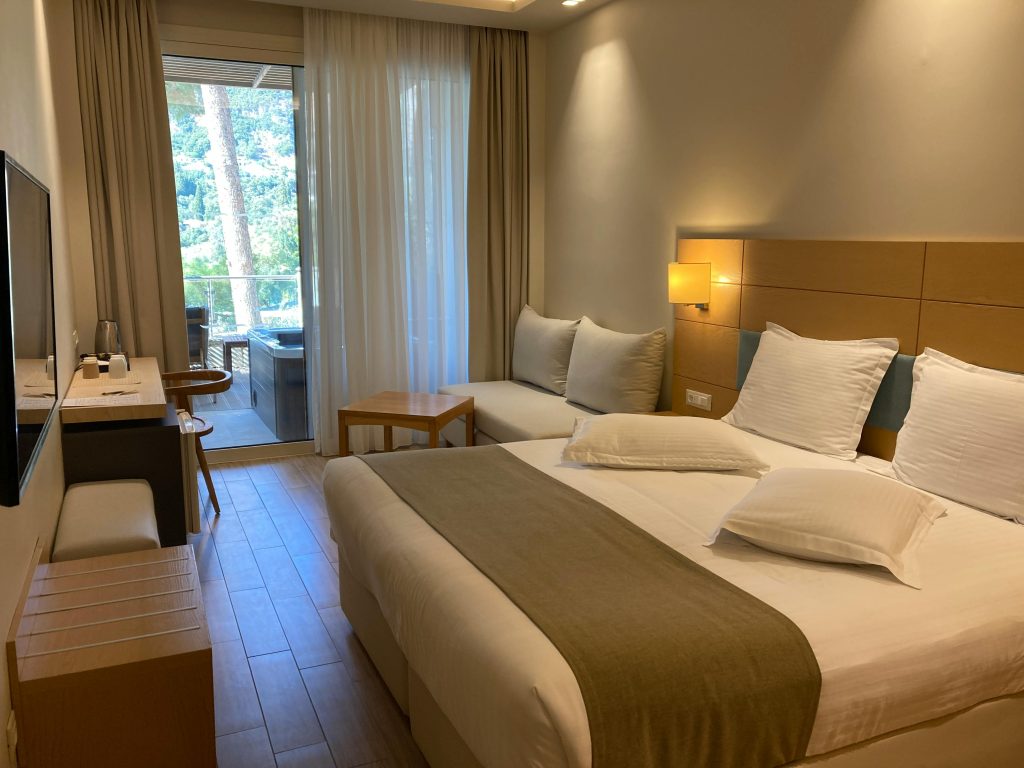 Modern hotel room interior in Corfu featuring a cozy balcony view.